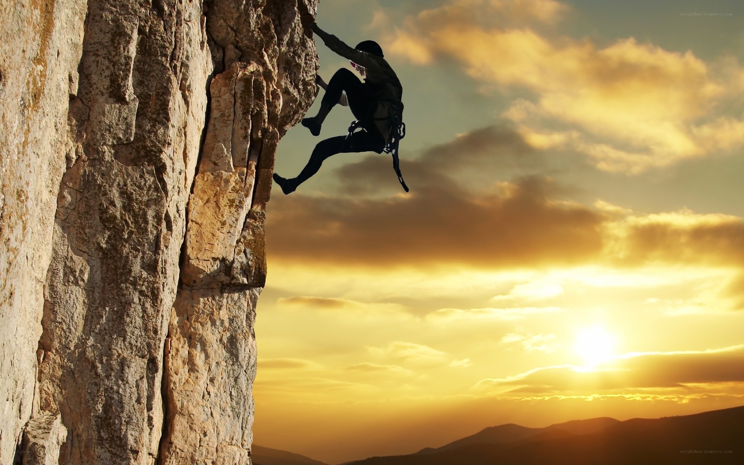 Climber on a cliff at sunset