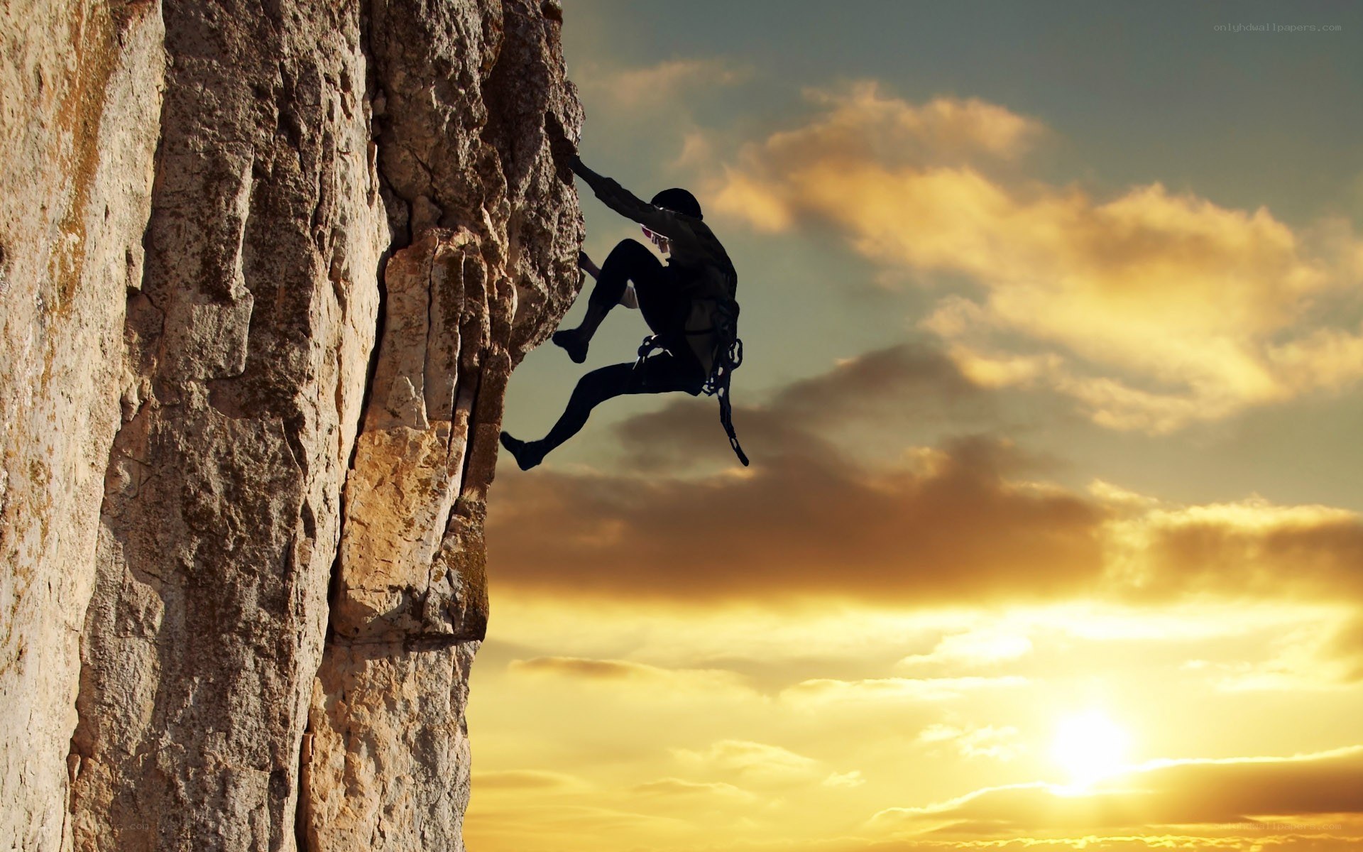 climber on a cliff at sunset