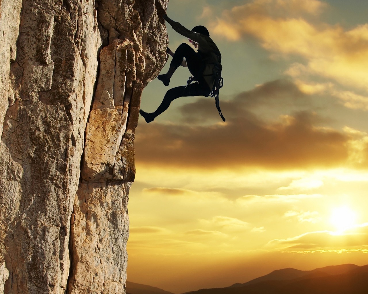 Climber on a cliff at sunset