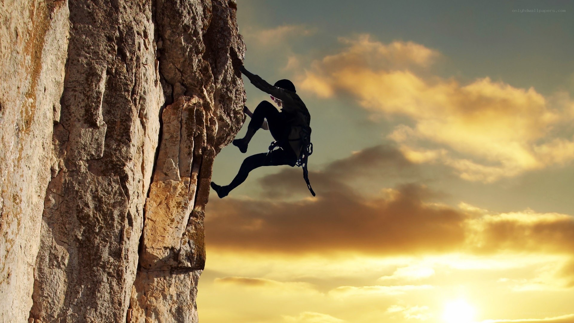 Climber on a cliff at sunset