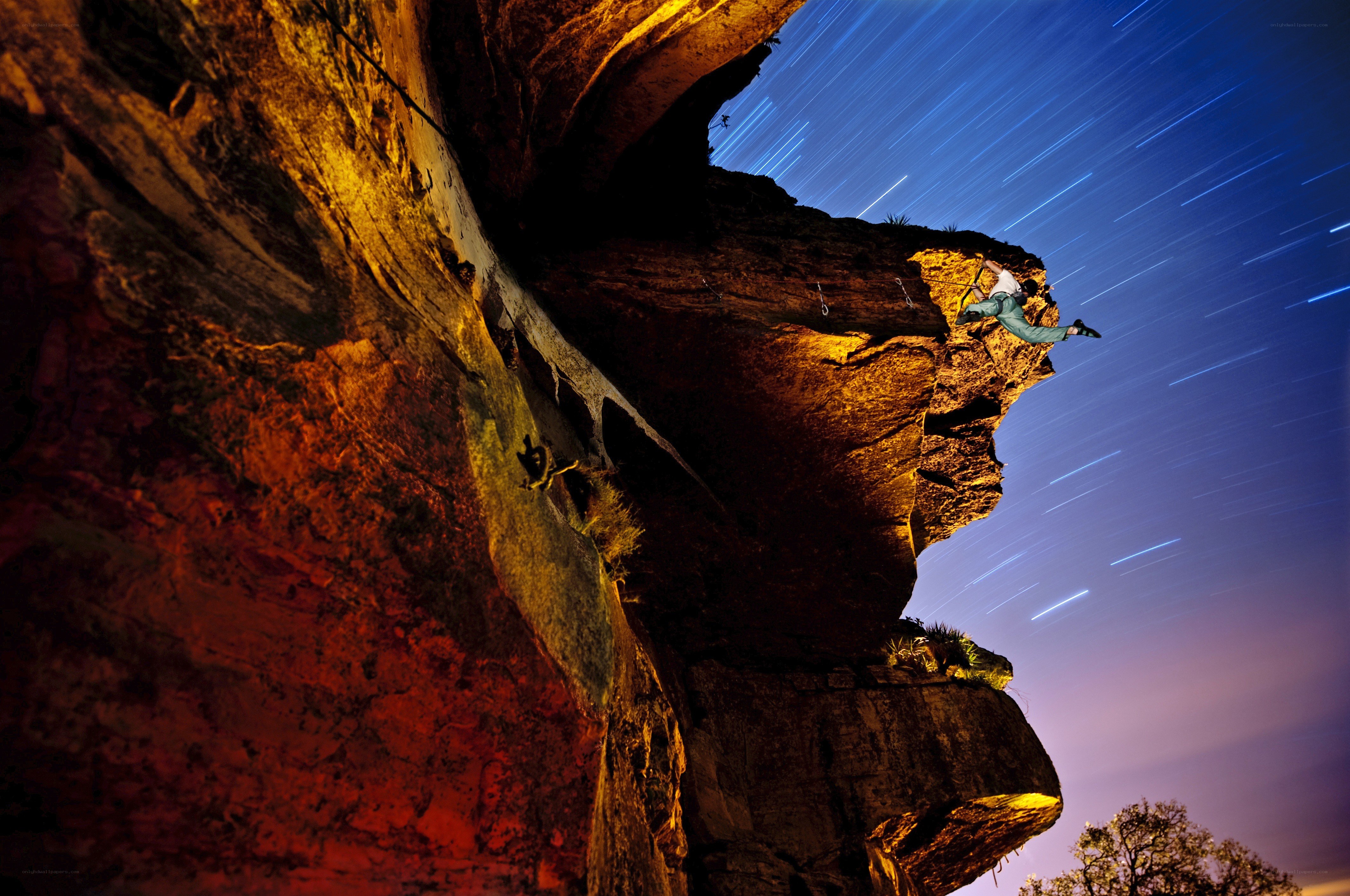 Climber on a rock face at night
