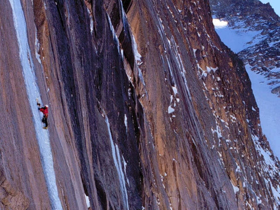 Climber on icy cliff face
