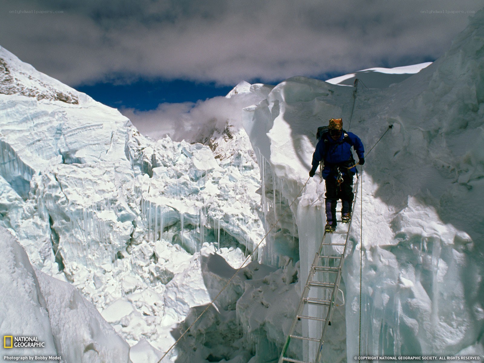 Climber on ladder over glacier