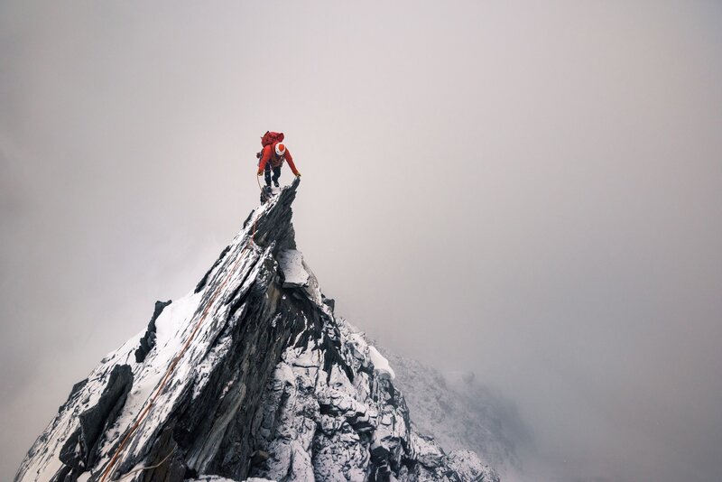 Climber on Mountain Peak — Gray, Dramatic, Winter, Photograph