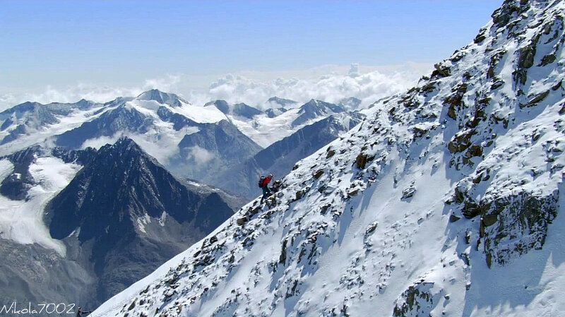 Climber on snowy mountain ridge