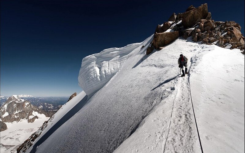 Climber on snowy mountain slope