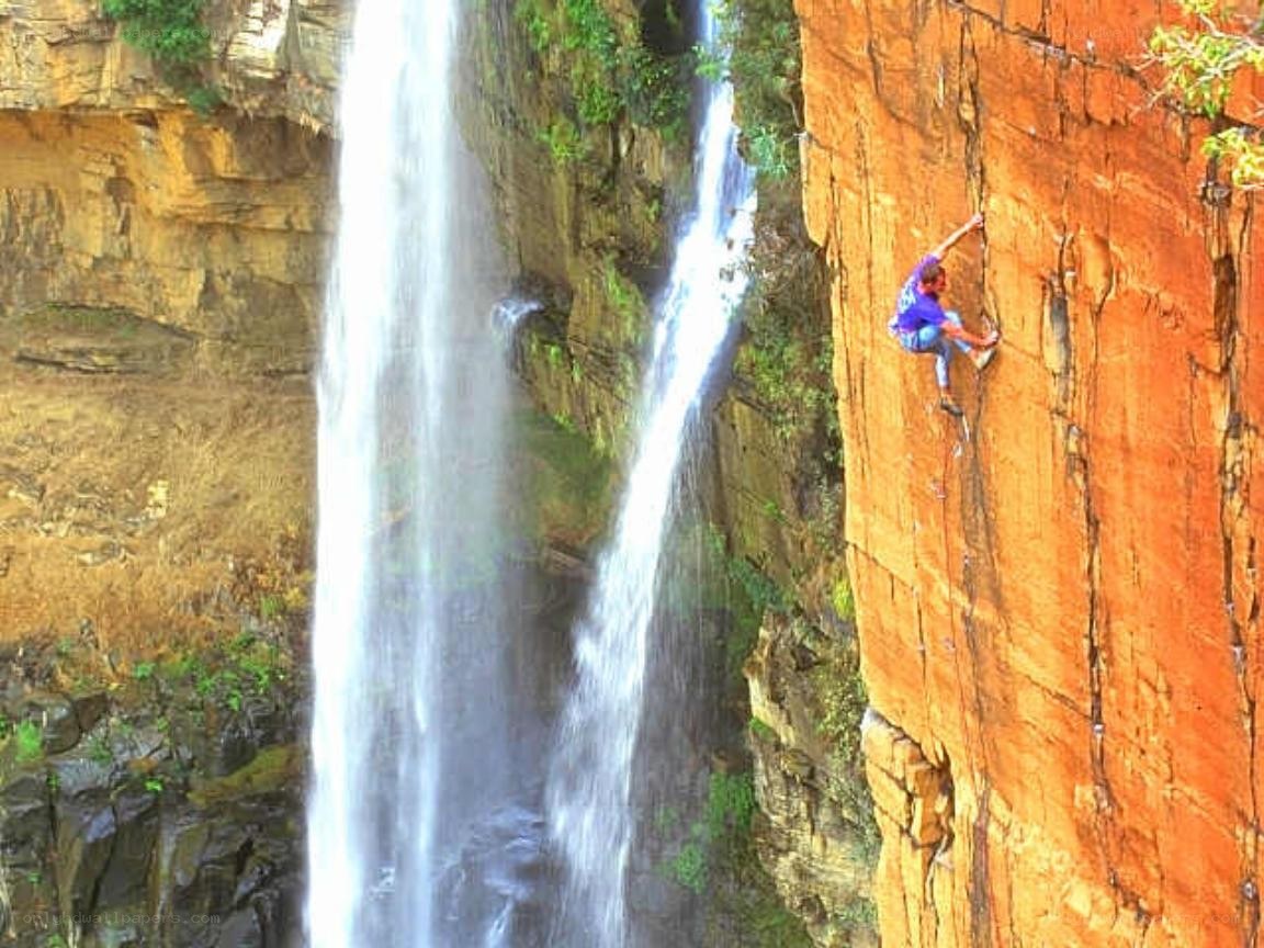 Climber on waterfall cliff