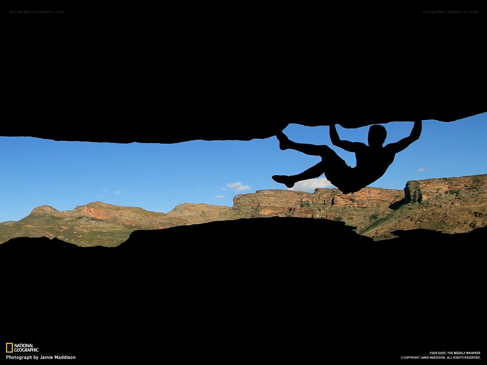Climber silhouetted against canyon