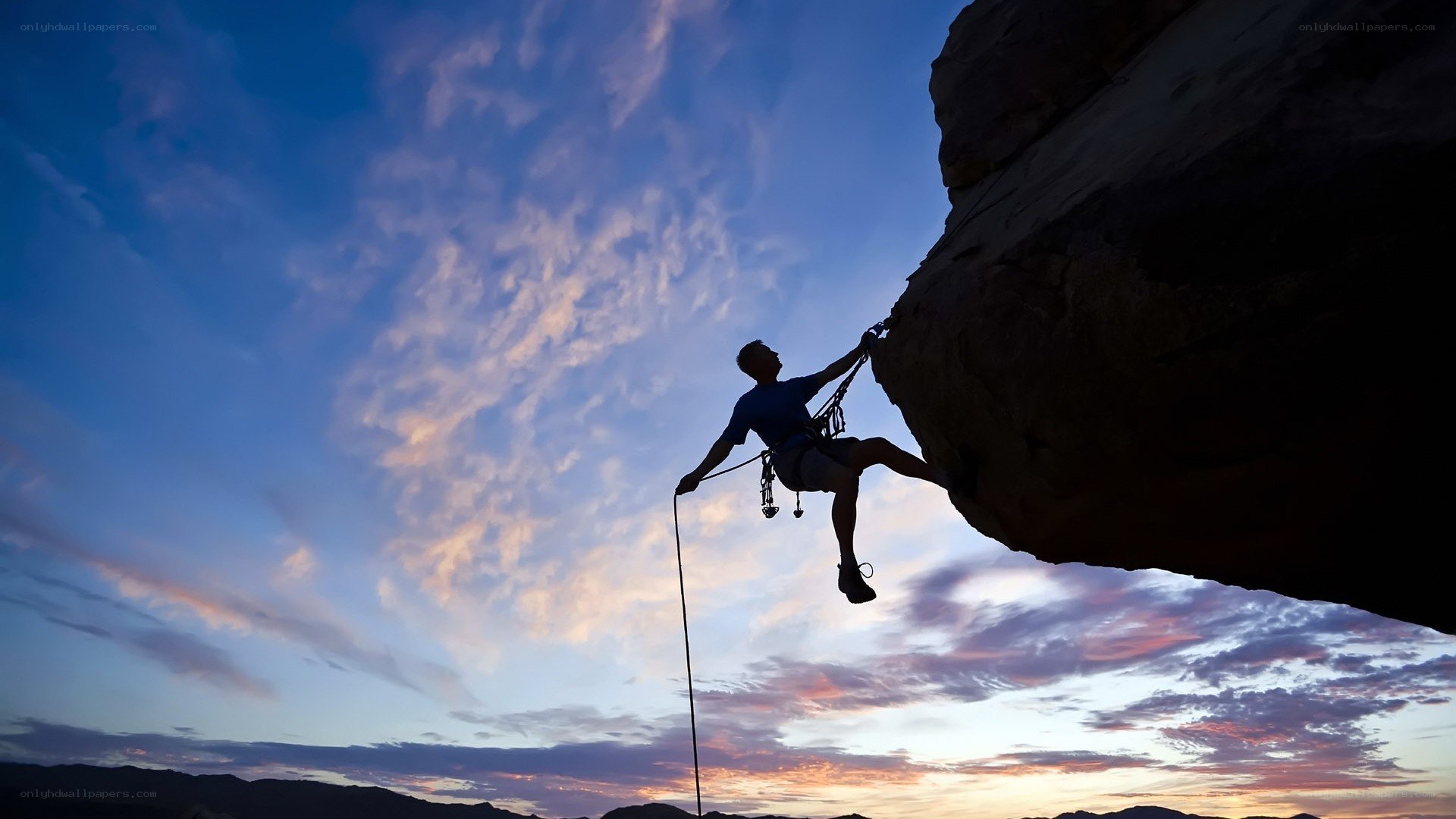 Climber silhouetted against sunset