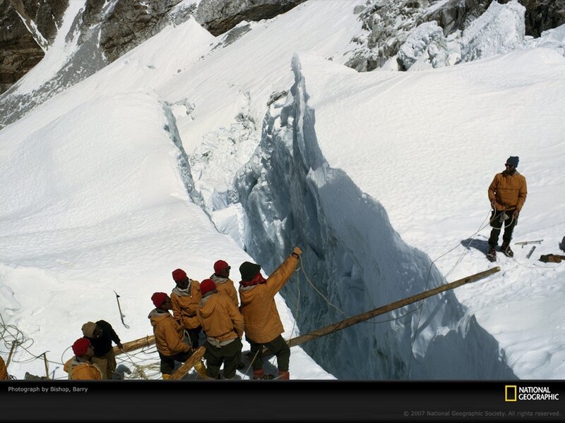 Climbers crossing a crevasse