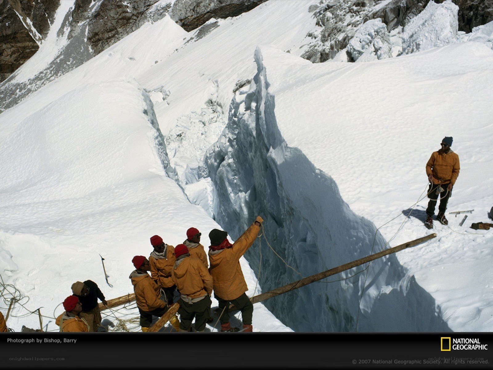 Climbers crossing a crevasse