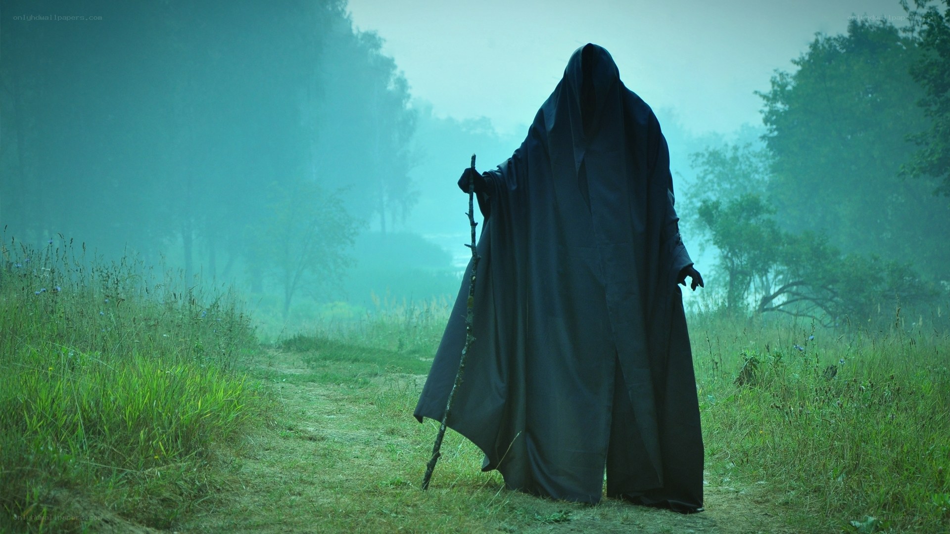 Cloaked figure in misty forest