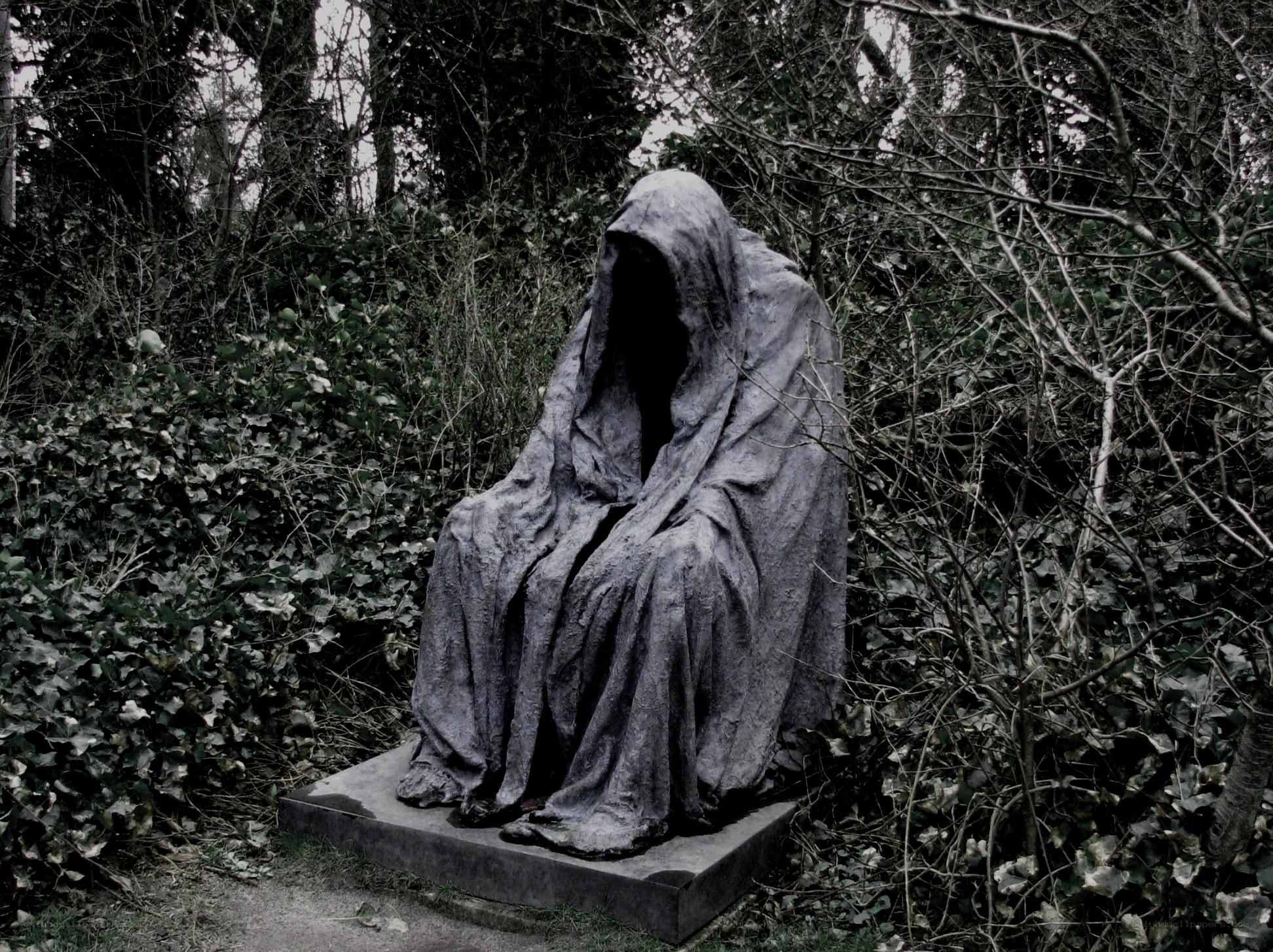 Cloaked figure statue in forest