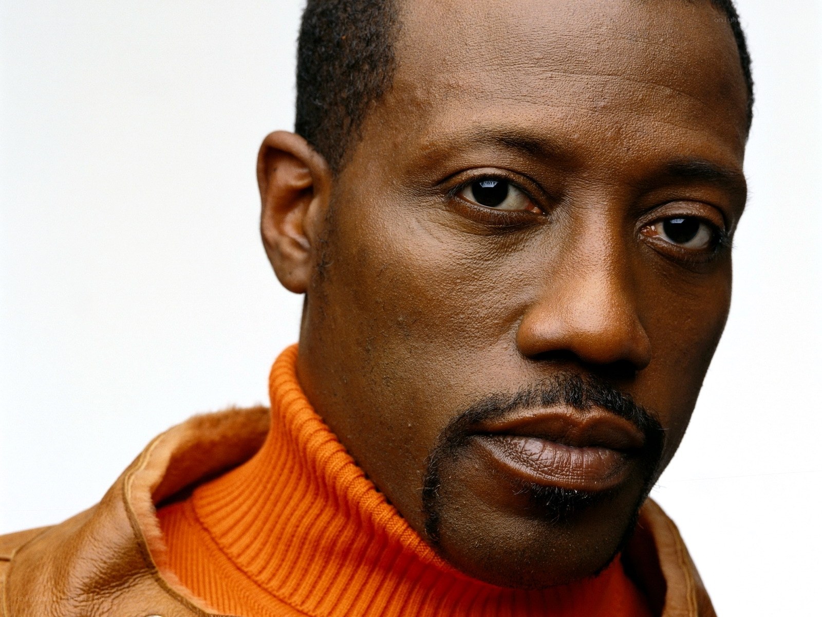 close-up of a man in an orange turtleneck