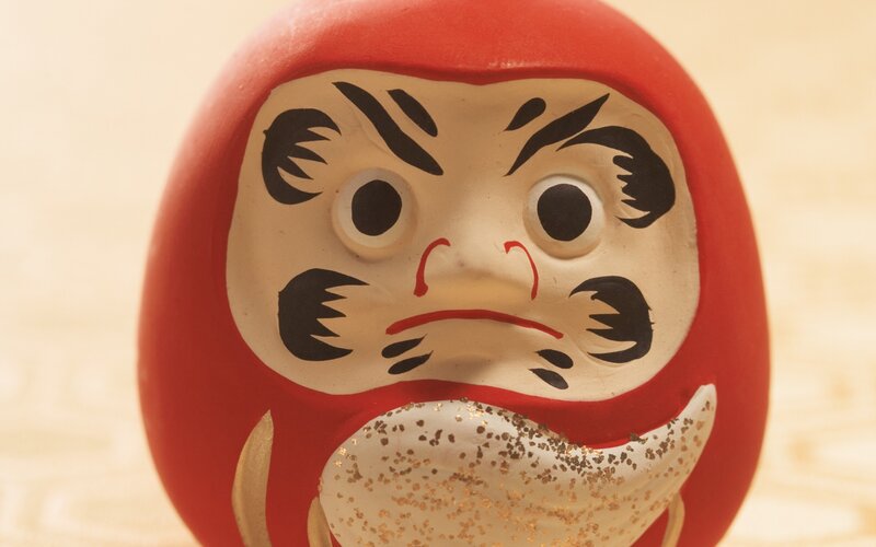 Close-up of a red Daruma doll