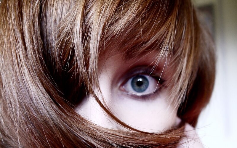 close-up of blue eye with hair