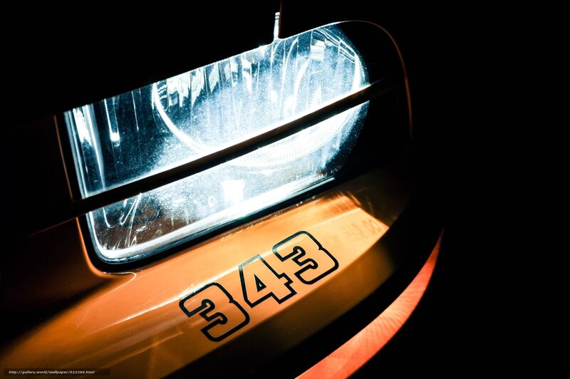 Close-up of car headlight with number