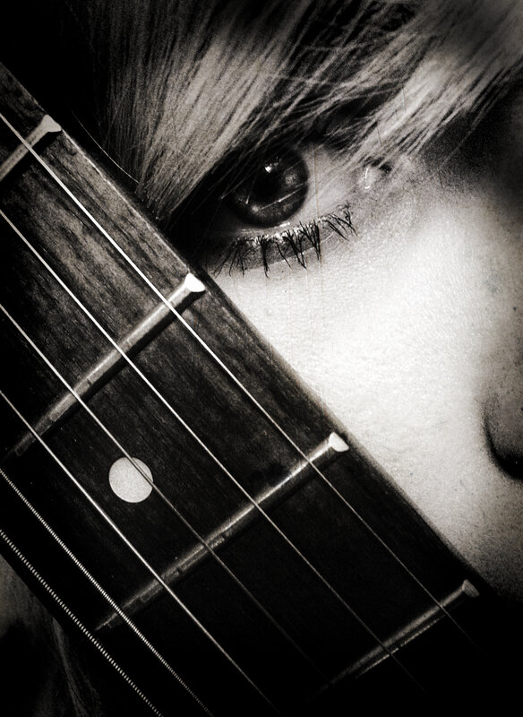 close-up of eye and guitar neck