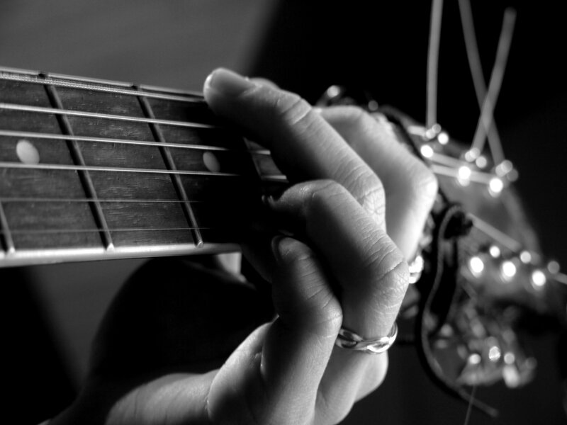 close-up of hand playing guitar