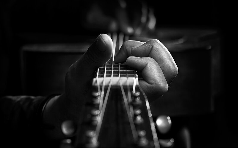close-up of hands on guitar
