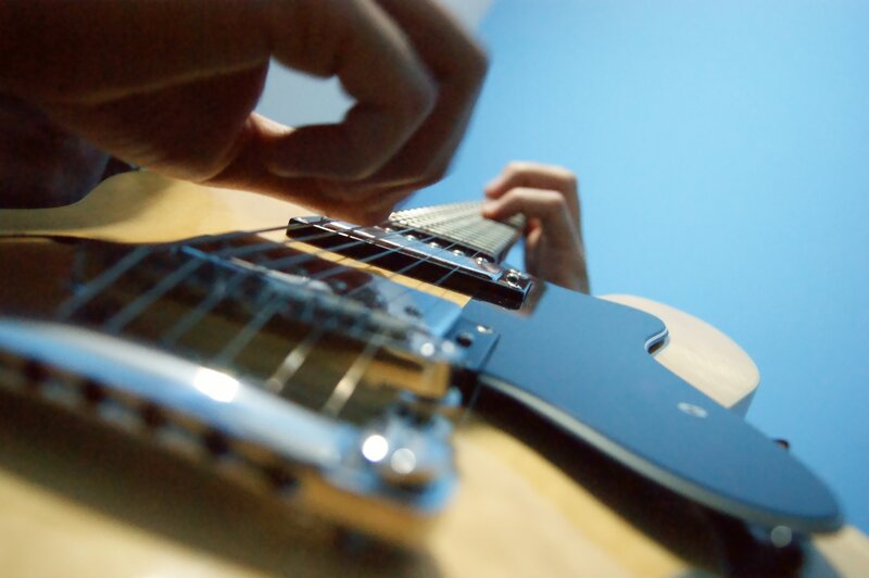 close-up of hands playing guitar