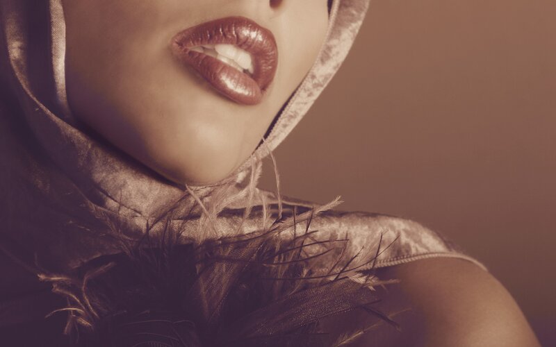 close-up of lips and feathered garment