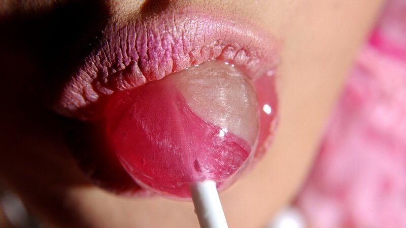 close-up of lips licking lollipop