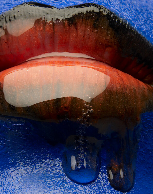 Close-up of lips with blue liquid