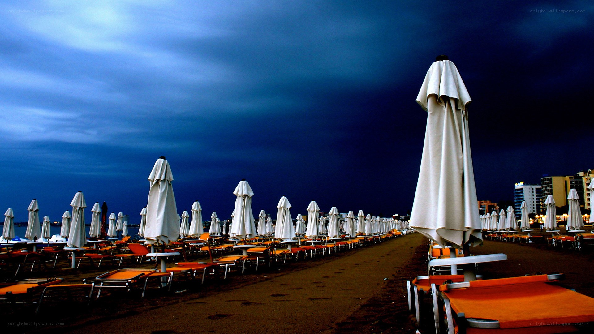 Closed beach umbrellas at dusk