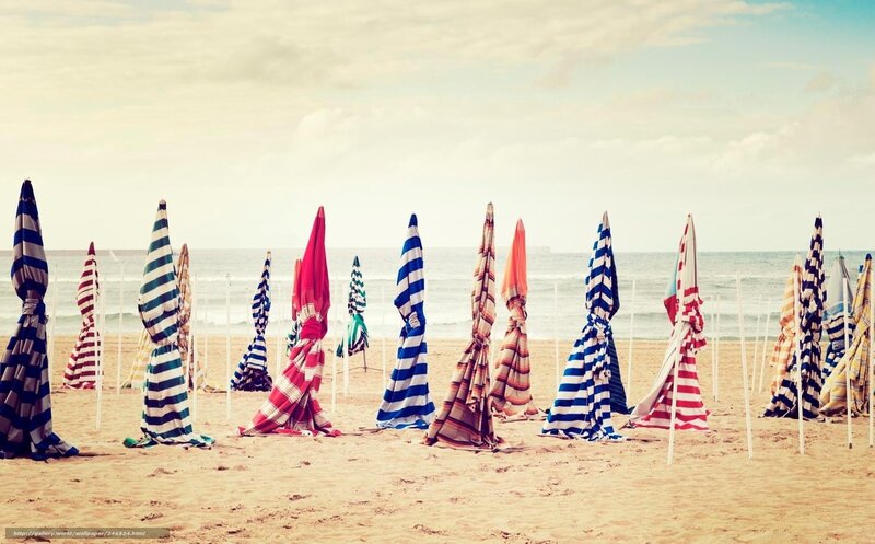 Closed beach umbrellas on sand