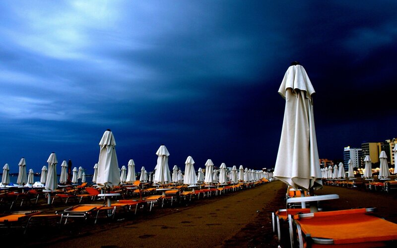 Closed Umbrellas on Beach — Blue, Dramatic, Night