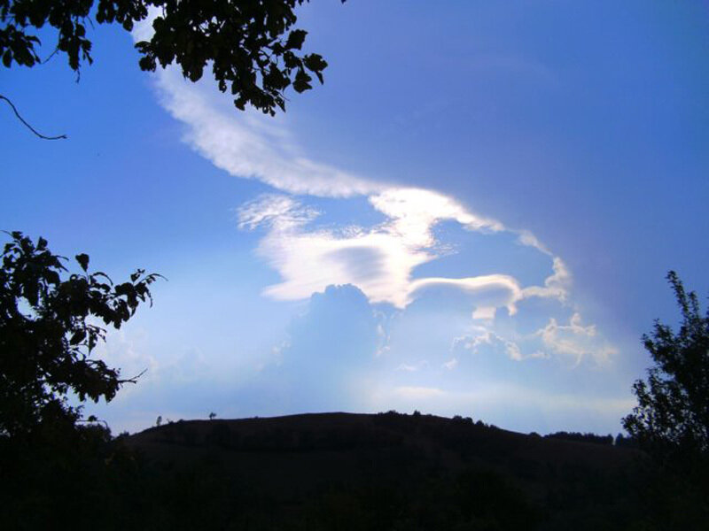 Cloud formation over a hill