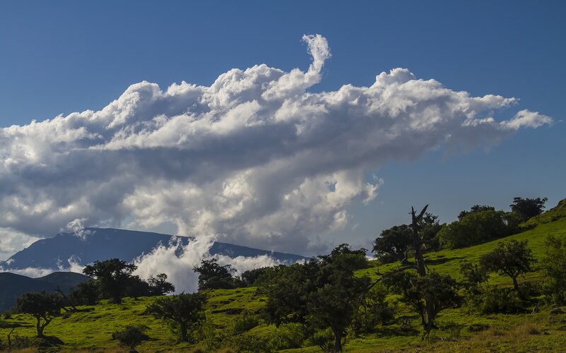 Cloud over green hills