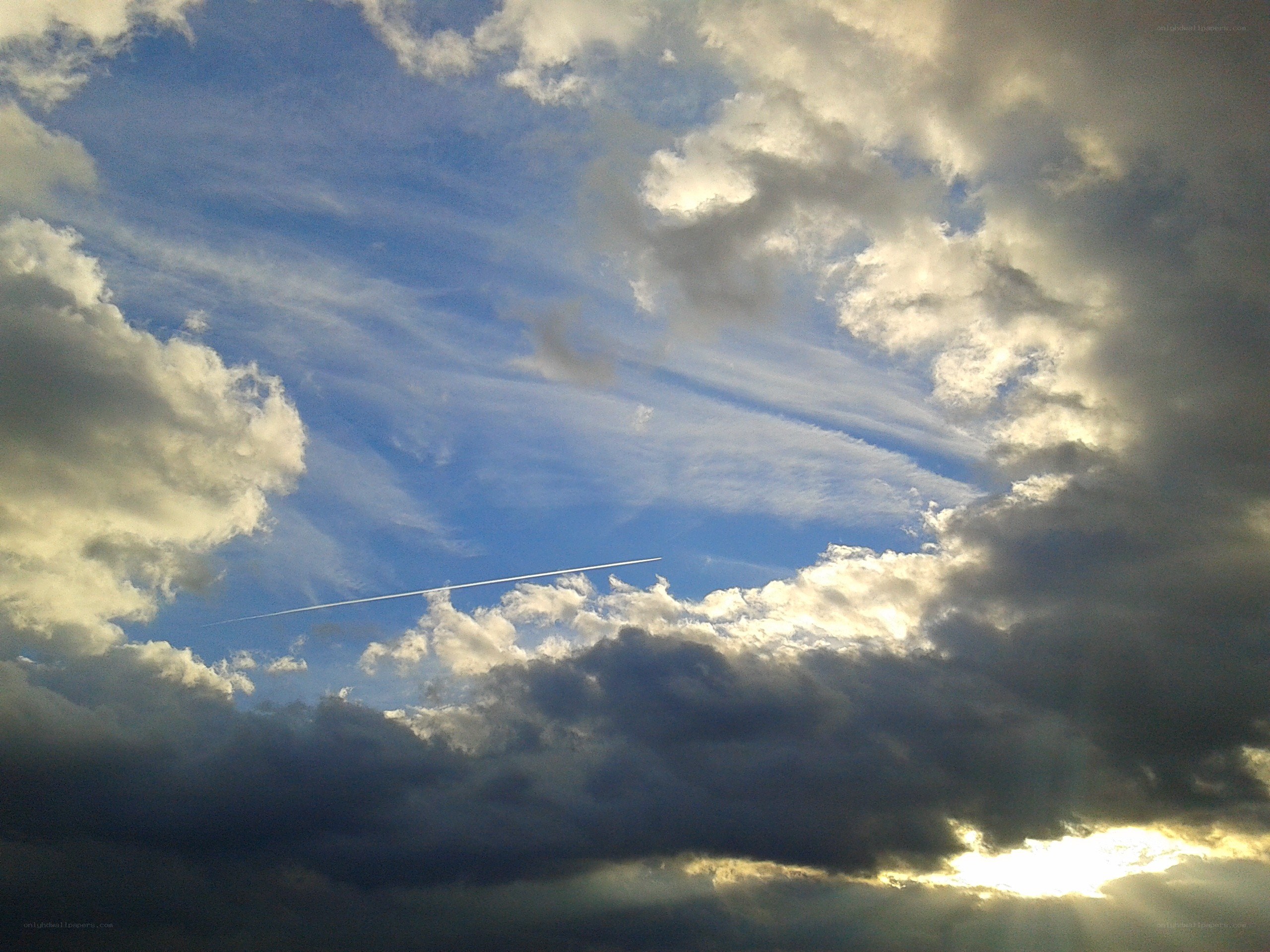 Clouds and contrail in blue sky