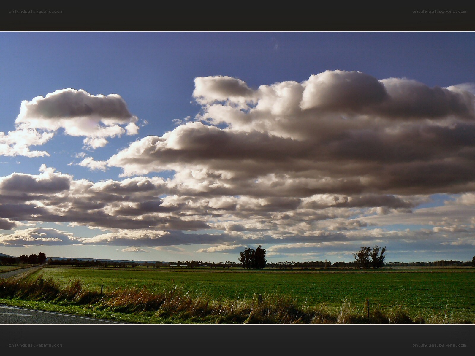 Clouds over a green field