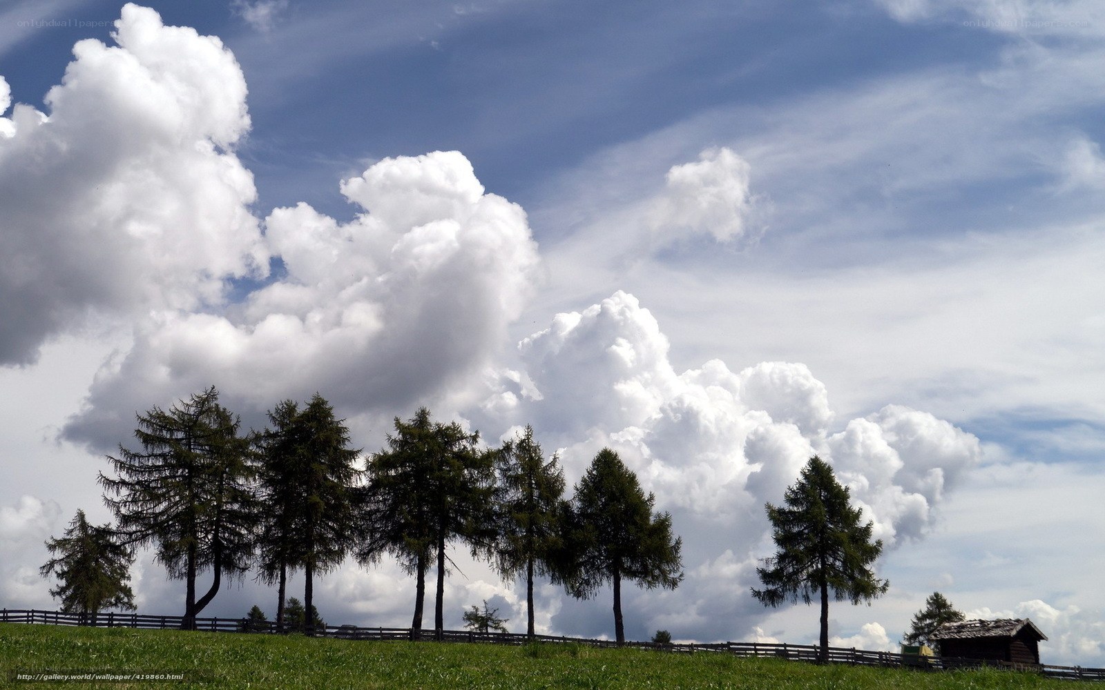 Clouds over a green hill