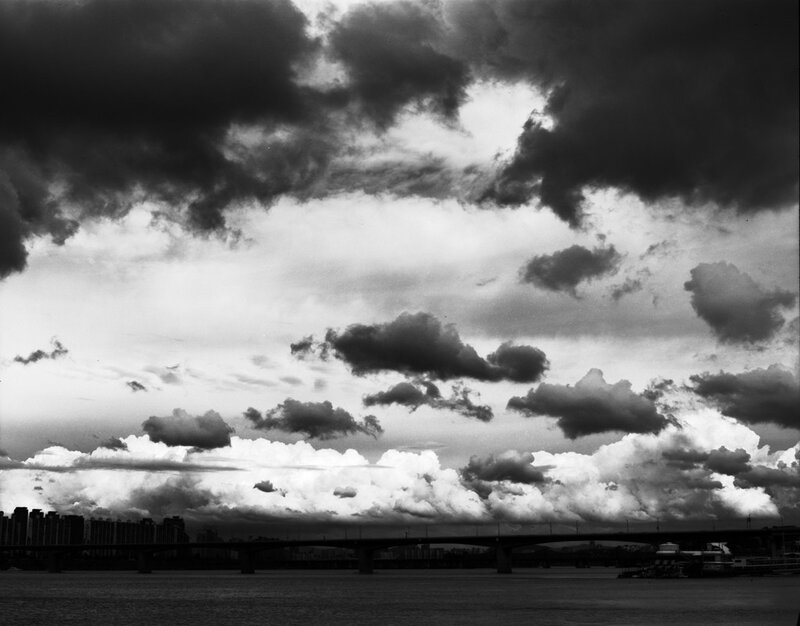 Clouds over a river bridge