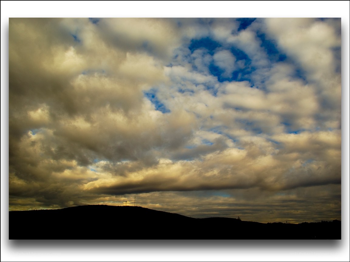 Clouds over a silhouetted hill