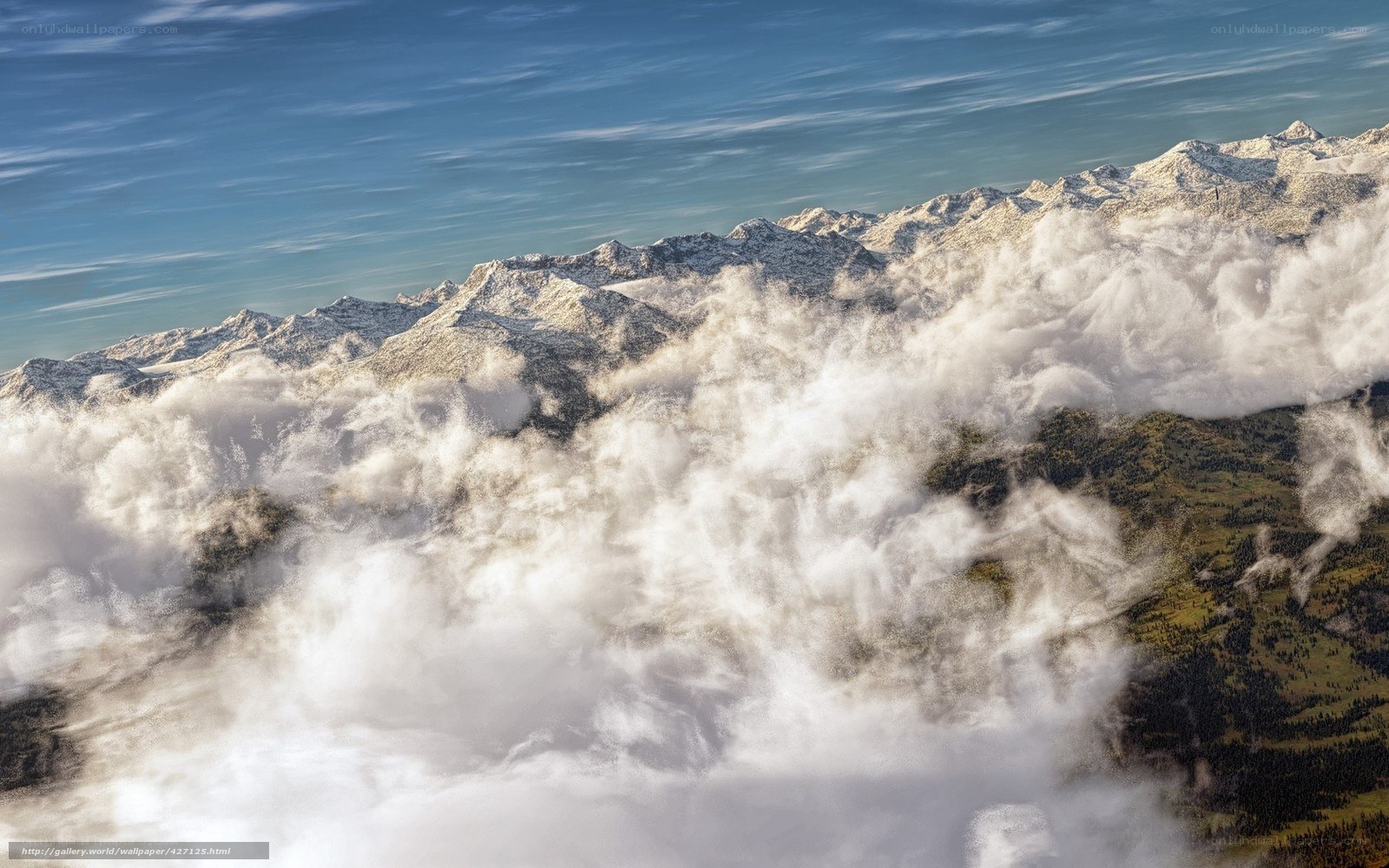 Clouds over snow-capped mountains