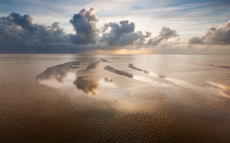 clouds reflected on wet sand