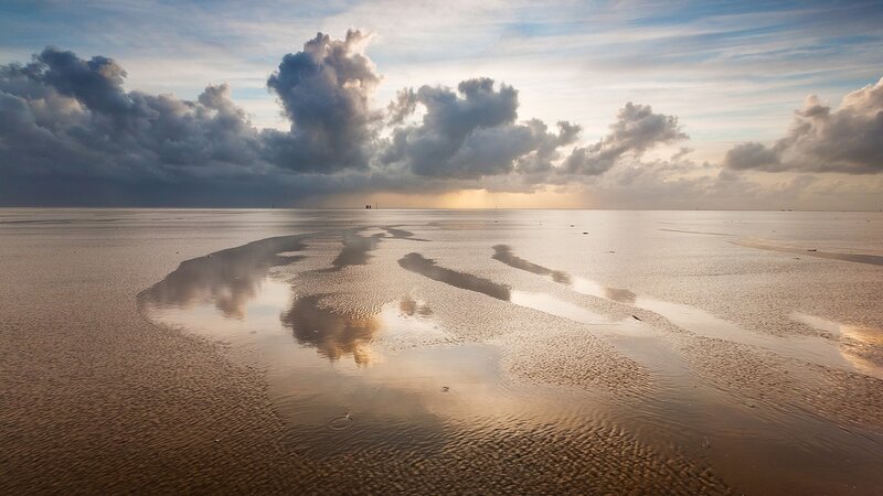 Clouds reflected on wet sand