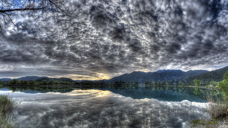 Cloudy lake with mountain reflection