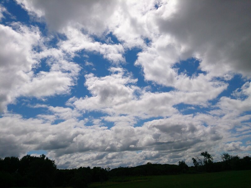 Cloudy sky over a green field