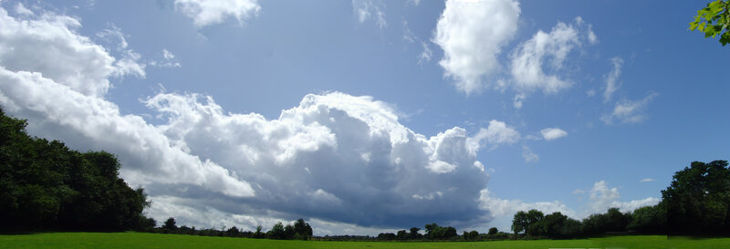 Cloudy sky over green field