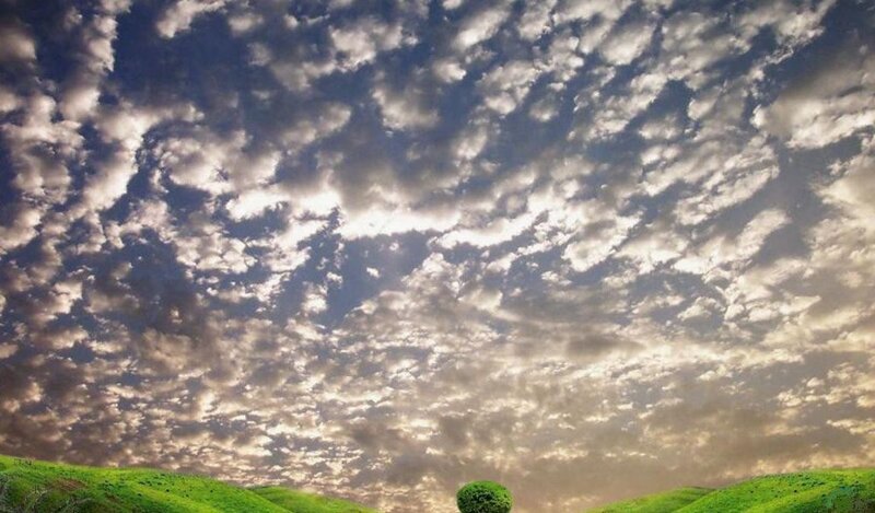 Cloudy sky over green hills