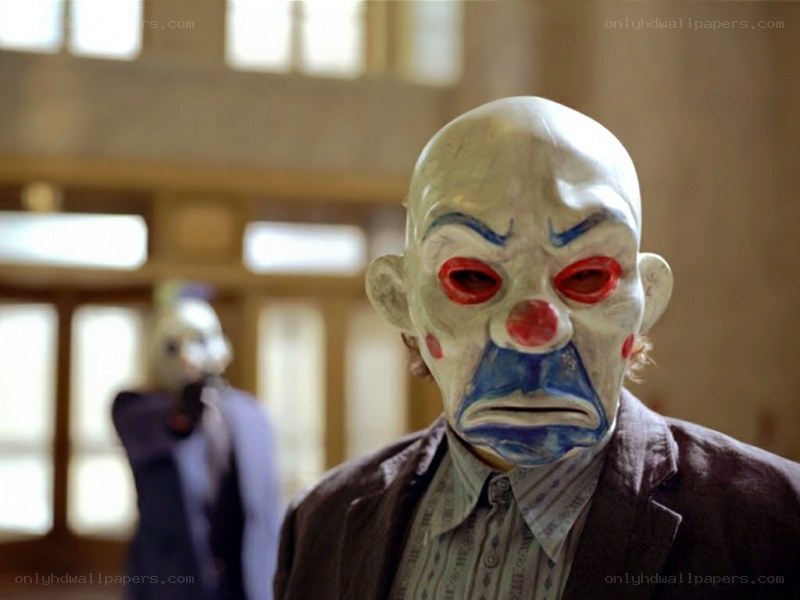 clown-masked figures in a hall