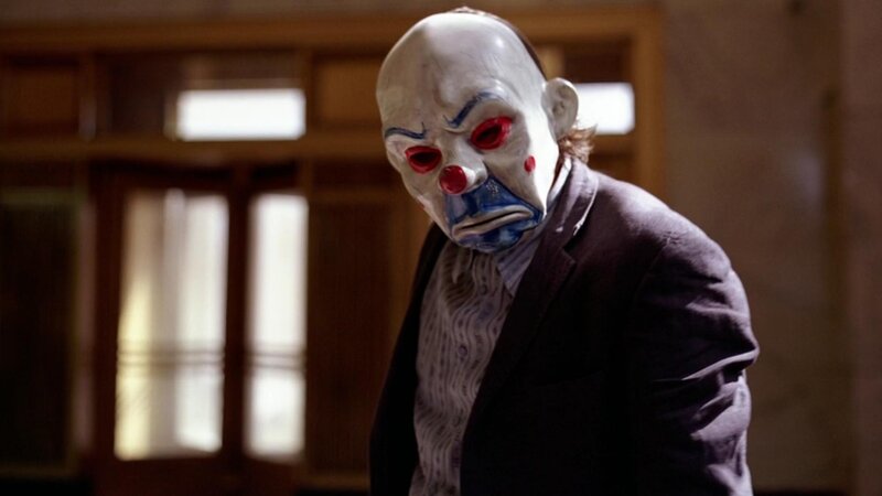 clown-masked man in suit