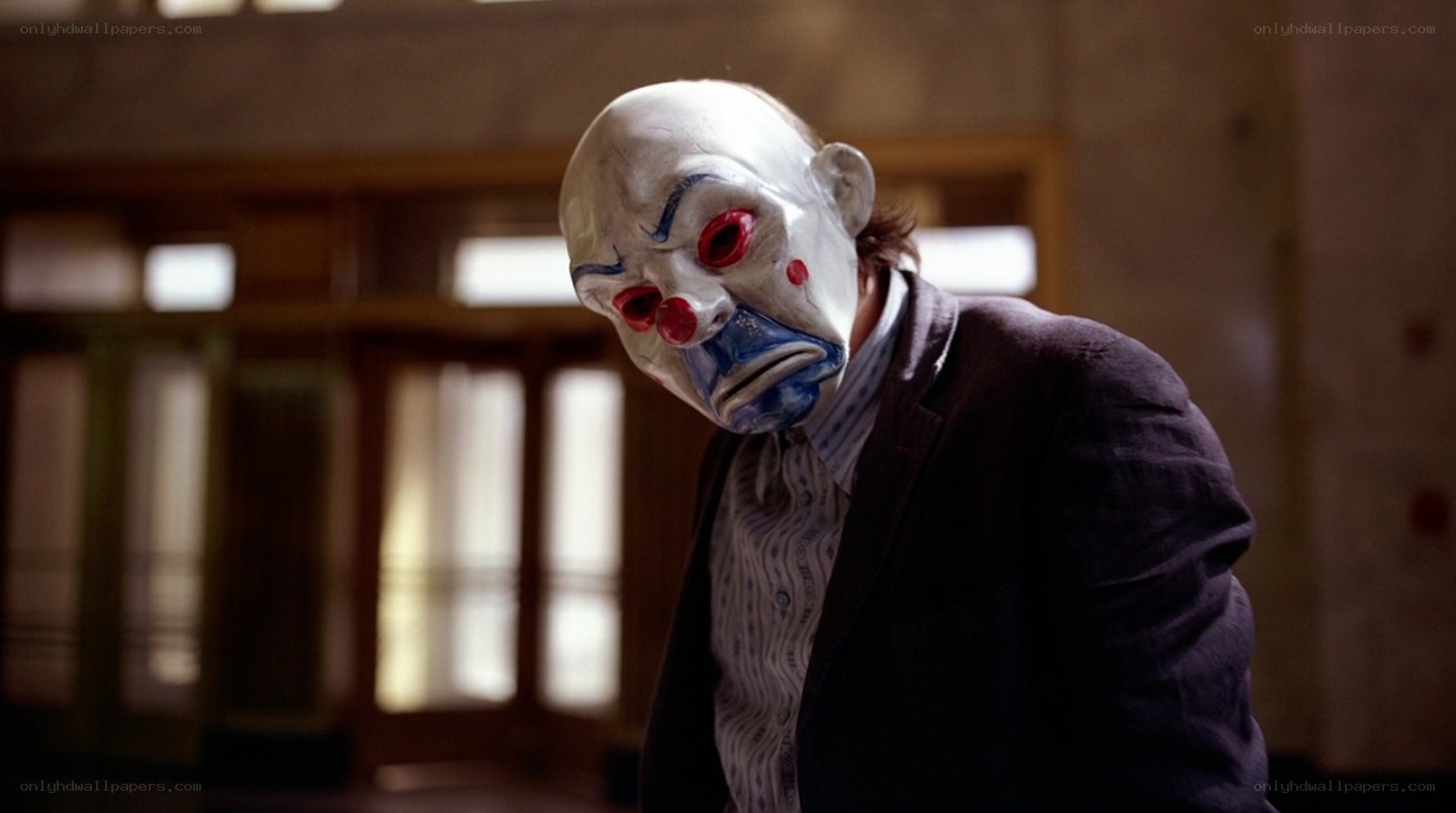 clown-masked man in suit