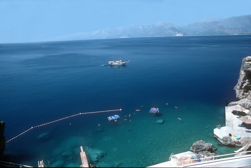 Coastal bay with sailboat and swimmers
