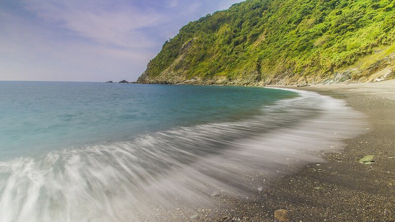 coastal beach with green cliffs